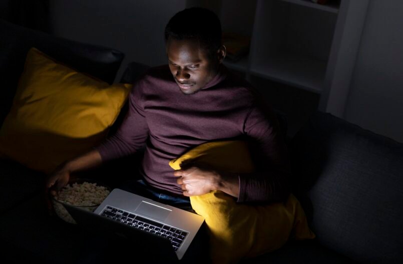 An African American man streaming a church service online
